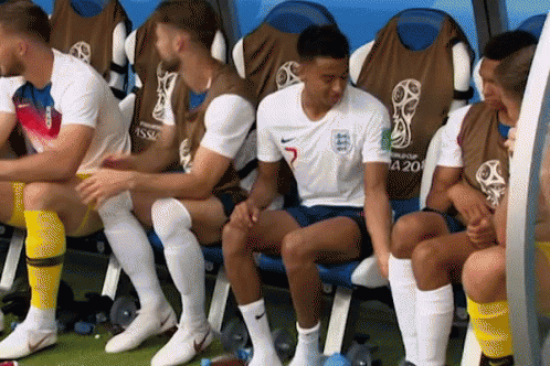 A Group Of Soccer Players Are Sitting In A Locker Room And One Of Them Has The Number 5 On His Jersey GIF