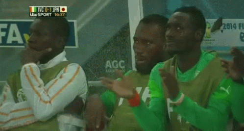 A Group Of Soccer Players Are Sitting In A Locker Room With A Sign That Says Agc On It GIF