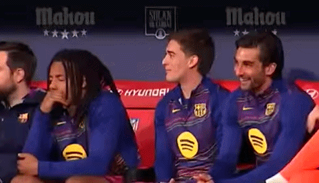 A Group Of Soccer Players Are Sitting On A Bench In A Locker Room . GIF