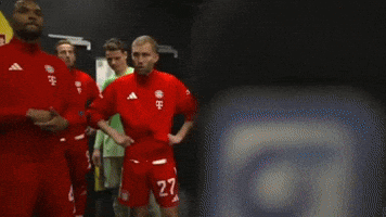 a group of soccer players are standing in a room with a yellow wall that says vodafone