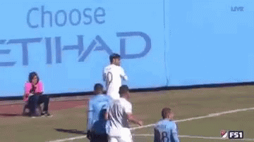 A Group Of Soccer Players Are Standing In Front Of A Blue Background . GIF