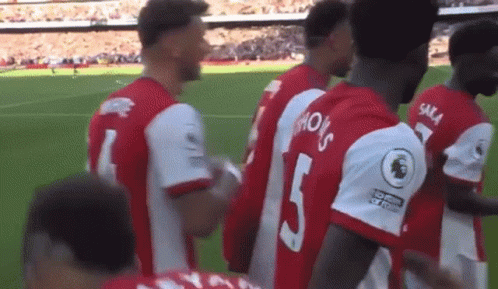 A Group Of Soccer Players Are Standing On A Soccer Field . GIF