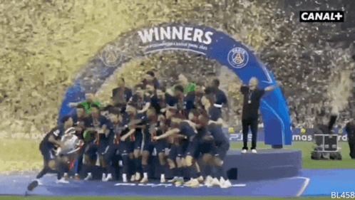 A Group Of Soccer Players Are Standing Under A Banner That Says " Winners " GIF