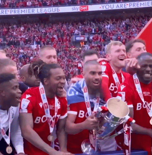 A Group Of Soccer Players Holding A Trophy In Front Of A Sky Bet Sign GIF