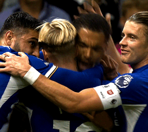 A Group Of Soccer Players Huddle Together With One Wearing A Wristband That Says ' Reebok ' On It GIF