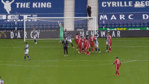 A Group Of Soccer Players On A Field In Front Of A Men 'S Wear Ad GIF