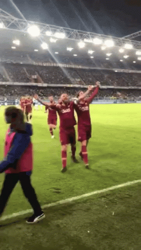 A Group Of Soccer Players Wearing Qatar Jerseys Celebrate GIF