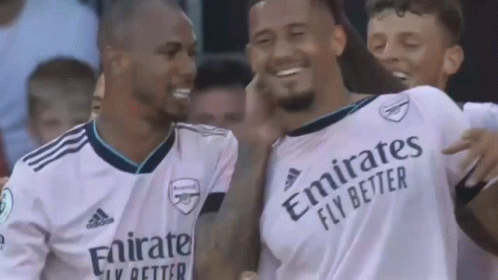 a group of soccer players wearing white jerseys with emirates fly better written on them are standing next to each other