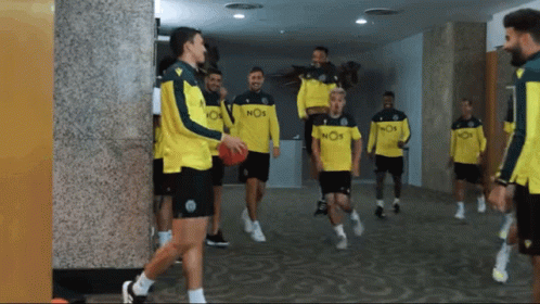 A Group Of Soccer Players Wearing Yellow Jerseys With Nos On Them GIF