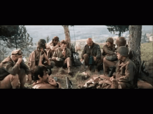 A Group Of Soldiers Are Gathered Under A Tree Talking GIF