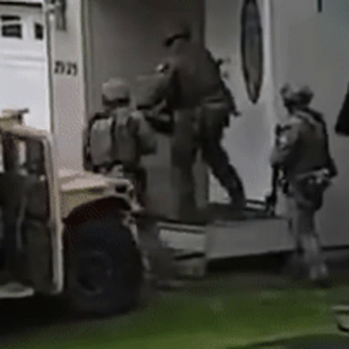 A Group Of Soldiers Are Getting Out Of An Ambulance In A Black And White Photo . GIF