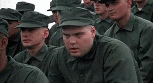 A Group Of Soldiers Are Sitting In A Row And Looking At The Camera . GIF