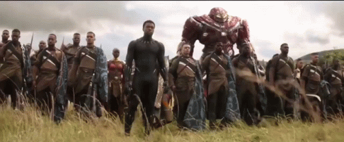 A Group Of Soldiers Are Standing In A Field With A Robot In The Background . GIF