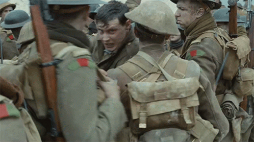 A Group Of Soldiers Are Standing In A Line And One Of Them Has A Red Patch On His Chest GIF
