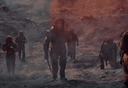 A Group Of Soldiers Are Standing In Front Of A Fire GIF