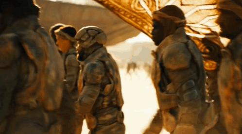 A Group Of Soldiers Are Standing In The Desert And One Of Them Has A Helmet On GIF