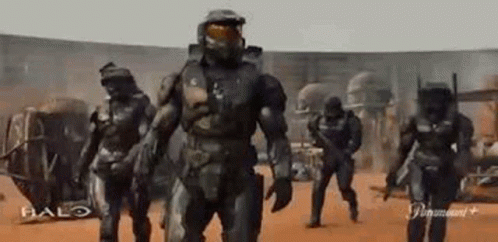 A Group Of Soldiers Are Walking In A Line In A Desert . GIF