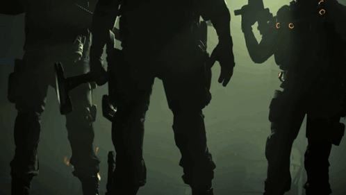 A Group Of Soldiers Standing In A Dark Room With A Hammer In Their Hand GIF