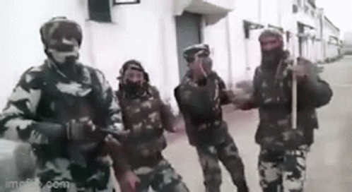 A Group Of Soldiers Standing Next To Each Other On A Street . GIF