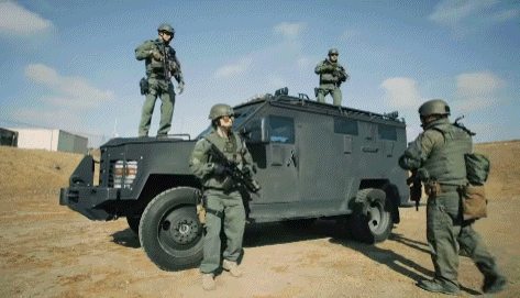 A Group Of Soldiers Standing On Top Of A Vehicle GIF