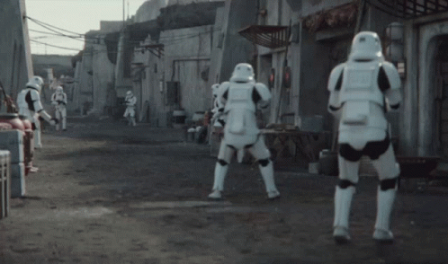 A Group Of Stormtroopers Are Standing On A Dirt Road GIF