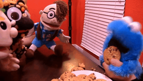 A Group Of Stuffed Animals Are Playing With Cookies On A Table GIF