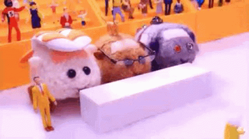A Group Of Stuffed Animals Are Standing Next To Each Other On A White Surface . GIF