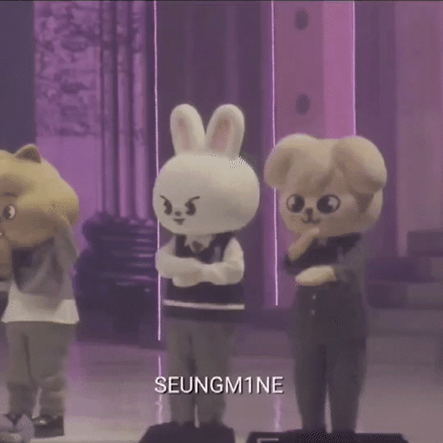 A Group Of Stuffed Animals Standing Next To Each Other On A Stage With The Name Seungm1ne On The Bottom . GIF