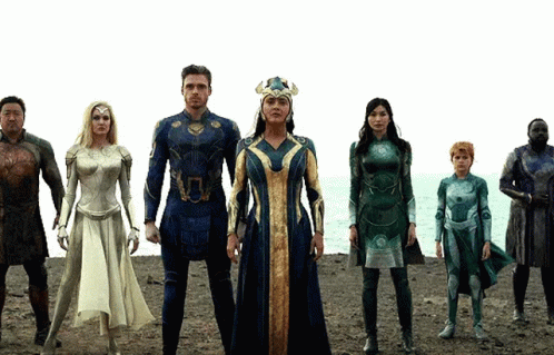 A Group Of Superhero Characters Are Standing On A Beach GIF