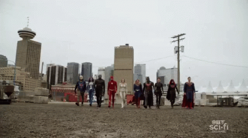 A Group Of Superheroes Walking In Front Of A City Skyline GIF