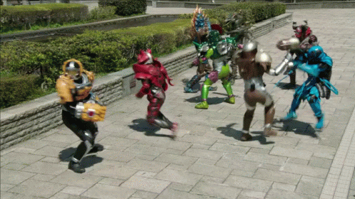 a group of superheros are standing on a sidewalk