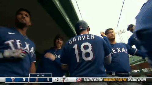 A Group Of Texas Rangers Players Standing In The Dugout GIF