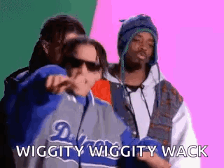 A Group Of Three Men Are Standing Next To Each Other And One Of Them Is Wearing A Jacket That Says Dodgers On It . GIF