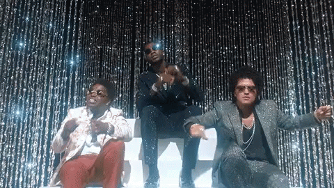 A Group Of Three Men Are Standing Next To Each Other In Front Of A Glittery Curtain . GIF