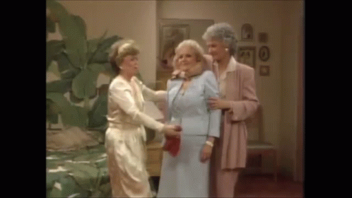 A Group Of Three Women Are Standing Next To Each Other In A Room . GIF