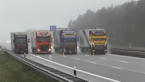 A Group Of Trucks Are Driving Down A Highway With A Sign That Says ' A / N ' On It GIF