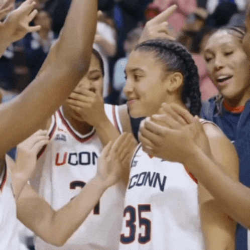 A Group Of Uconn Basketball Players Are Clapping Together GIF