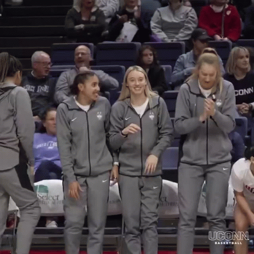 A Group Of Uconn Basketball Players Are Standing On The Court GIF