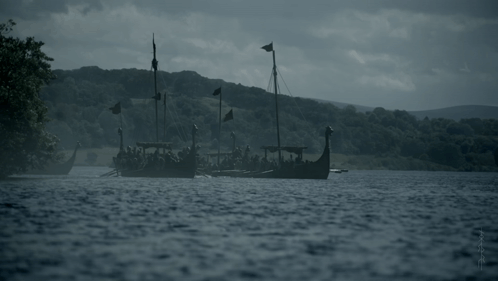 a group of viking boats are floating in a lake
