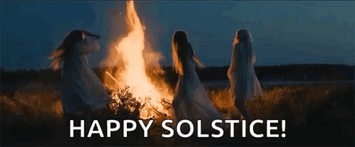 A Group Of Women Are Dancing Around A Fire In A Field At Night . GIF