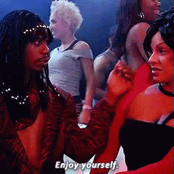 A Group Of Women Are Dancing In A Club And One Of Them Is Saying Enjoy Yourself GIF