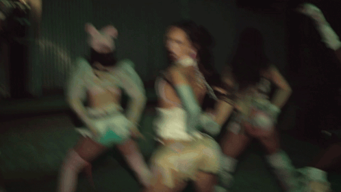 A Group Of Women Are Dancing In A Dark Room And One Is Wearing A Pink Cat Hat GIF