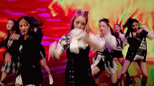 A Group Of Women Are Dancing In Front Of A Red Background . GIF