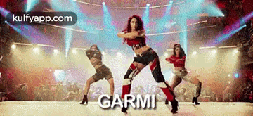 A Group Of Women Are Dancing On A Stage In Front Of A Crowd And The Word Garmi Is On The Bottom . GIF