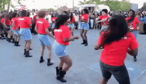 A Group Of Women Are Dancing Together In A Parking Lot . GIF