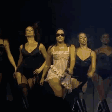 a group of women are dancing together on a stage
