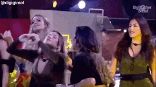 a group of women are dancing together on a stage in a club .