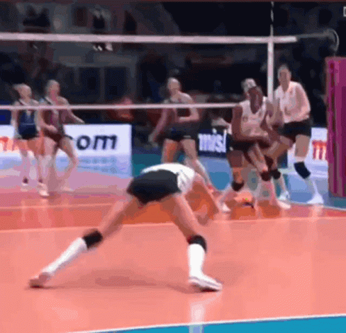 A Group Of Women Are Playing Volleyball On A Court With A Sign That Says Om GIF