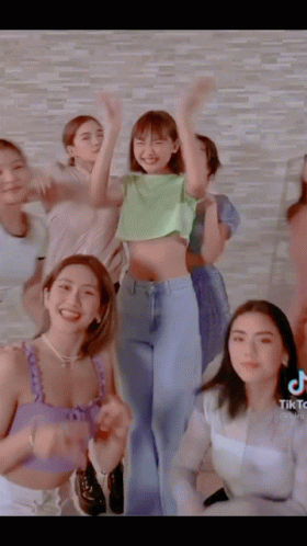 A Group Of Women Are Posing For A Picture And One Of Them Has A Green Shirt On GIF