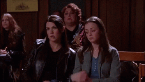 A Group Of Women Are Sitting In A Room And One Of Them Is Holding A Cell Phone . GIF